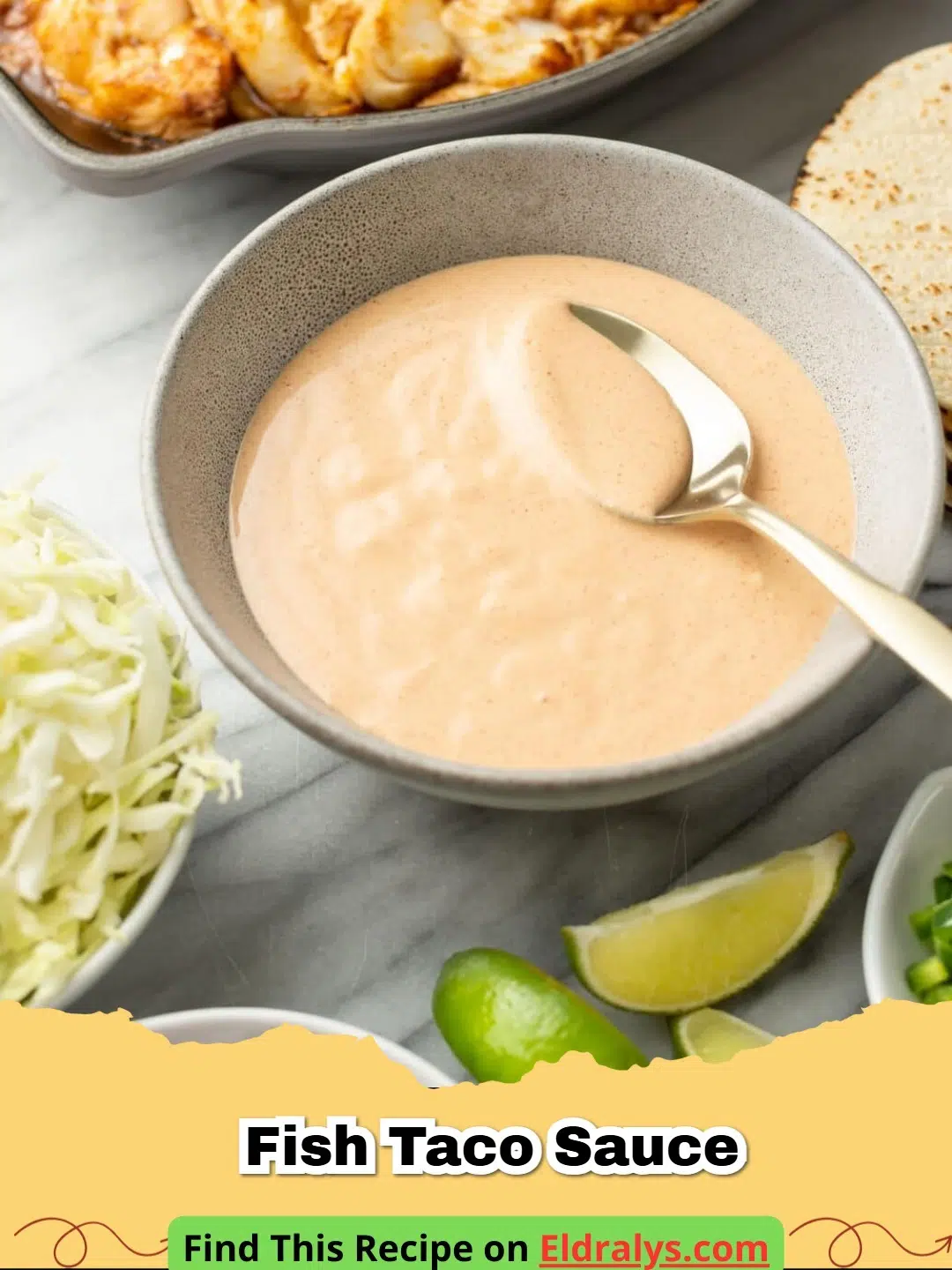 A glass bowl filled with creamy Fish Taco Sauce garnished with a lime wedge