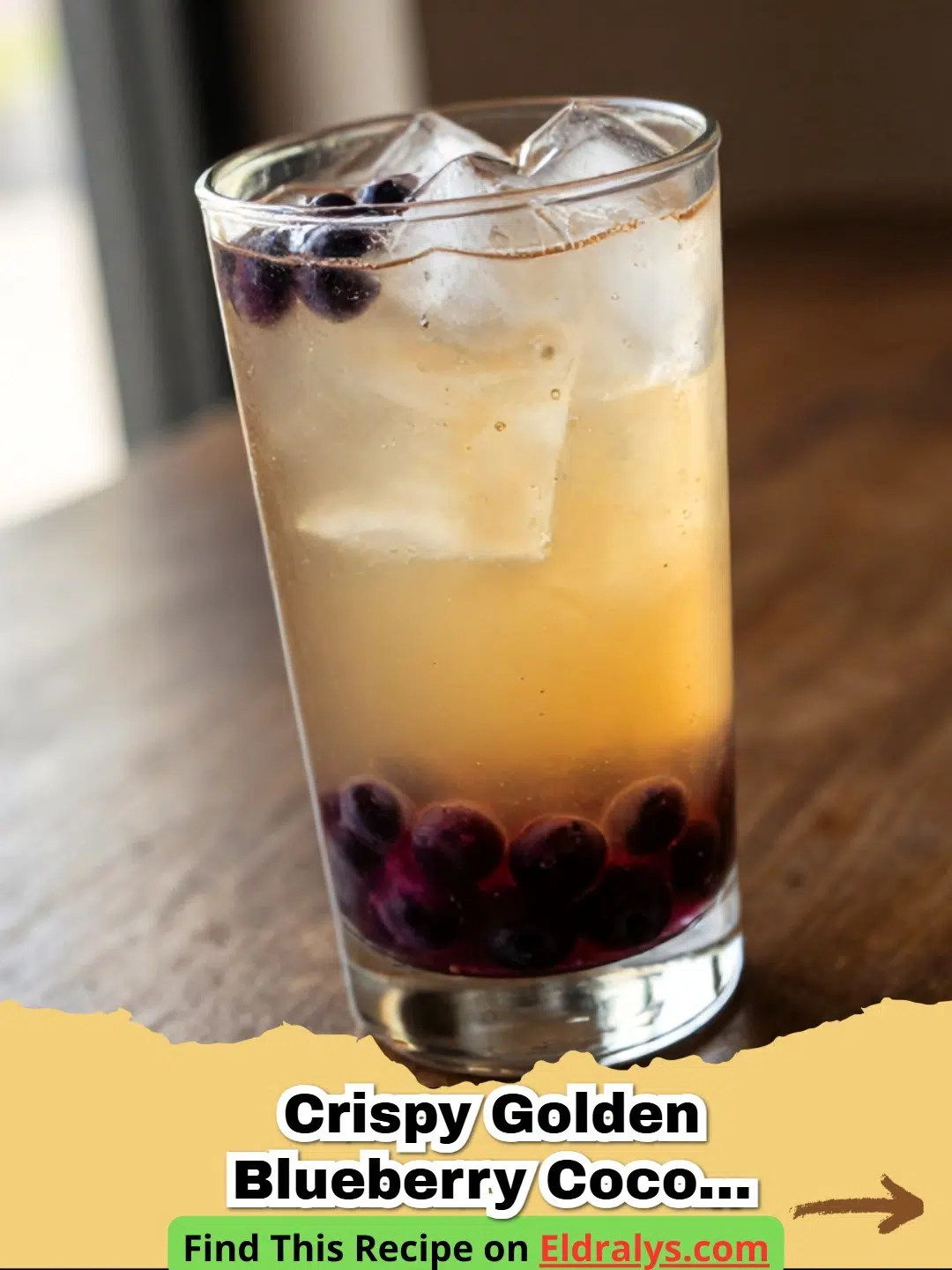A tall glass of Crispy Golden Blueberry Coconut Water Drink with mint and lemon.
