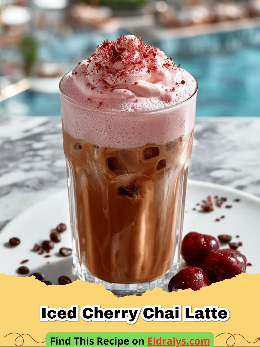 A tall glass of Iced Cherry Chai Latte with ice and fresh cherries