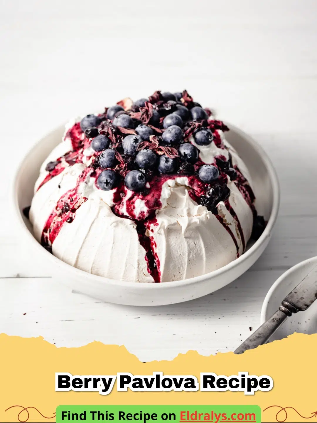 Berry Pavlova Recipe - A beautiful Berry Pavlova topped with whipped cream and mixed summer berries on a white plate.